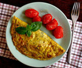 Omelette al formaggio con pomodori e cipolle arrostiti